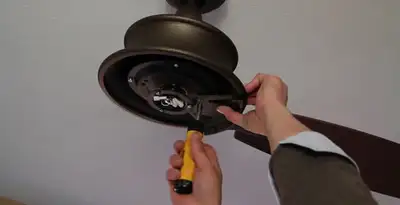 Electrician installing ceiling fan mounting bracket and fixture in Tacoma, WA