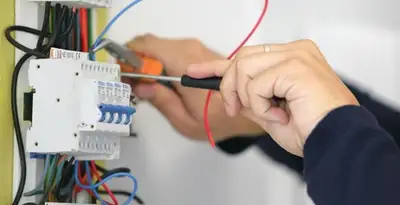 Electrician installing and adjusting circuit breakers in an electrical panel in Tacoma, WA