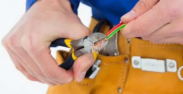 licensed electrician securing electrical wiring with professional tools during service work in Tacoma, WA