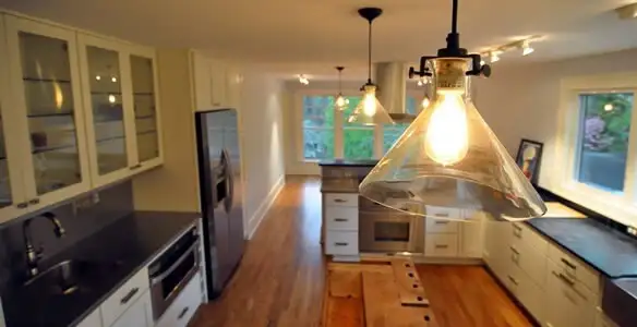 Residential electrician installing modern indoor light fixture in a home in Tacoma, WA