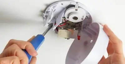 Certified technician wiring smoke detector during installation in Tacoma, WA